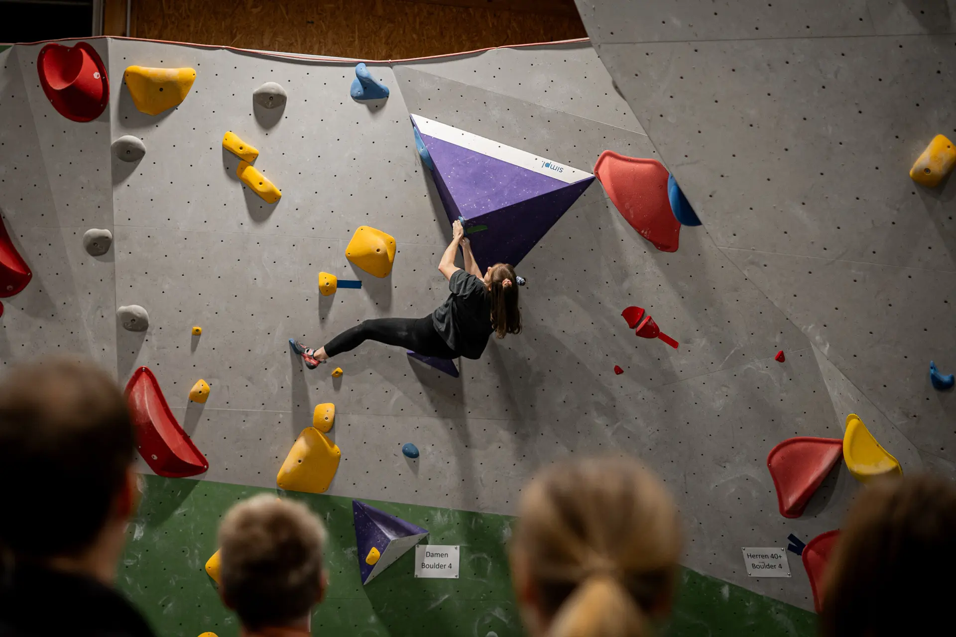 Frau beim Bouldern an der blauen Route | © diekletterarena