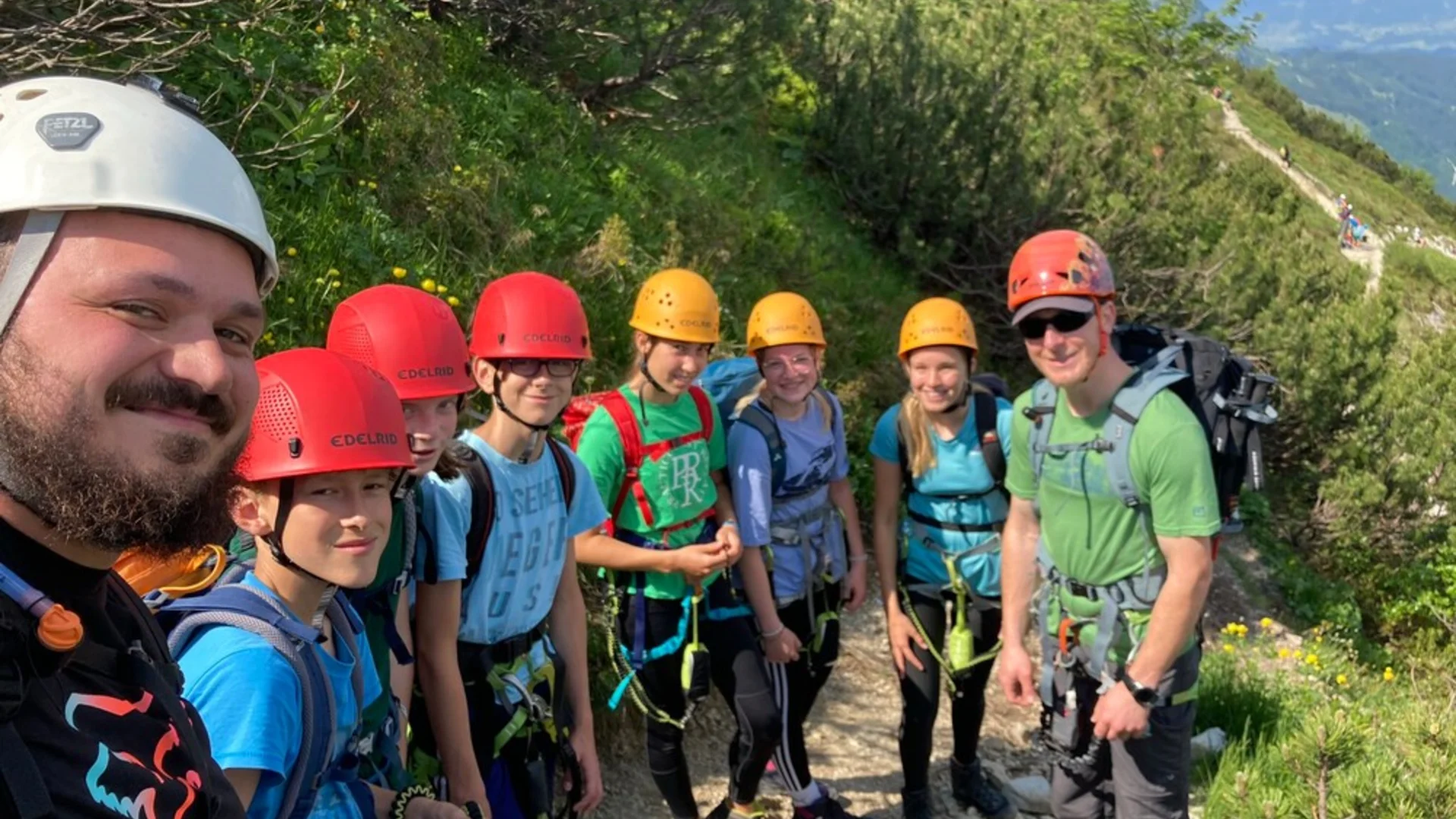 zwei Männer mit einer Kindergruppe beim Wandern an einem Steinpfad, umgeben von blühenden Pflanzen an einem Berg | © DAV Heilbronn BZG Öhringen