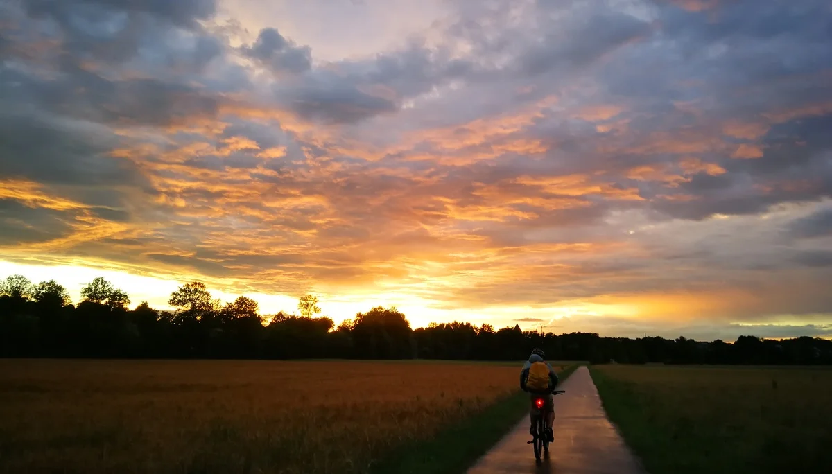 Radfahrer von hinten auf einem Feldweg bei Sonnenuntergang | © DAV Heilbronn BZG Öhringen