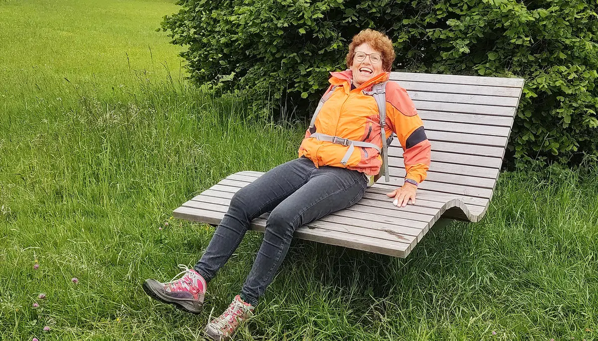Frau beim Wandern auf einer Holzliege | © DAV Heilbronn