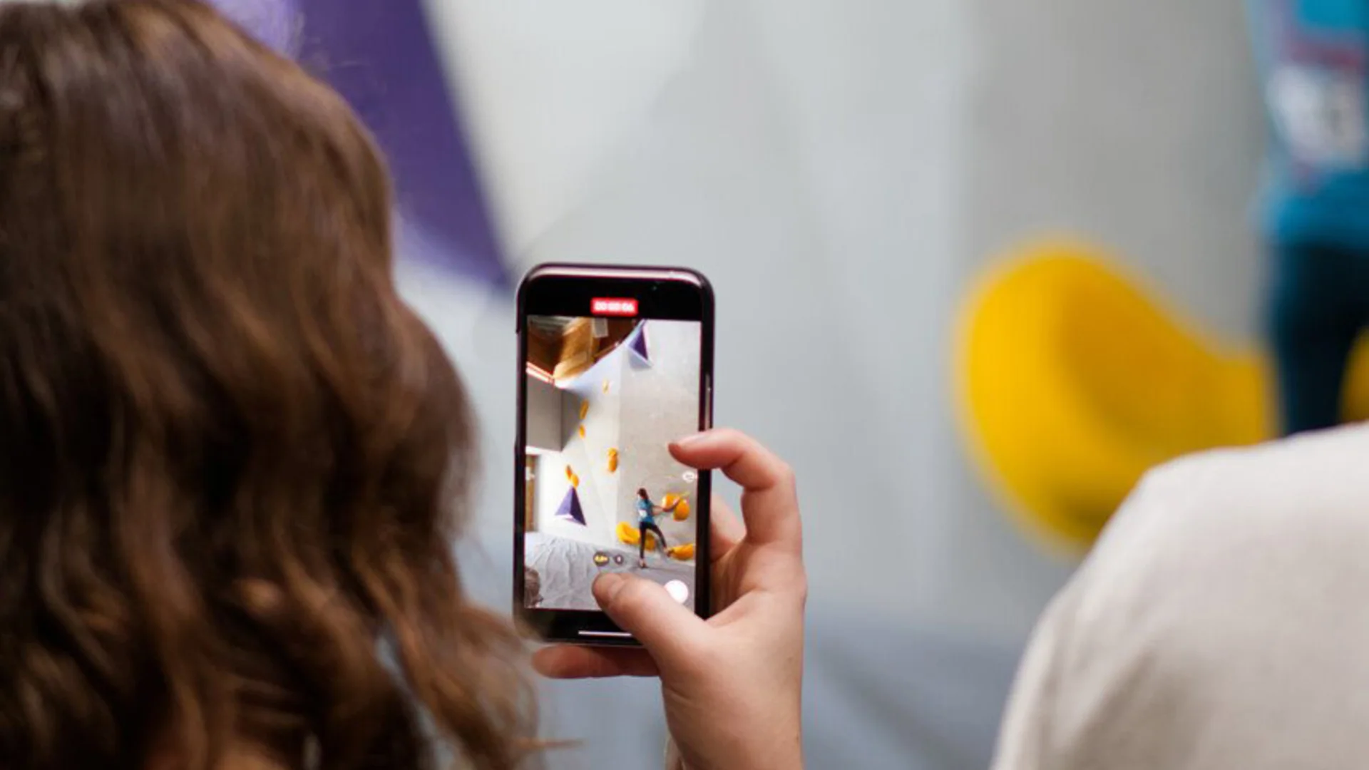 Nahaufnahme einer Frau von hinten, die mit ihrem Smartphone von einem kletternden Kind ein Foto schießt | © DAV Heilbronn Leistungsabteilung DAV Heilbronn | © DAV Heilbronn Leistungsabteilung