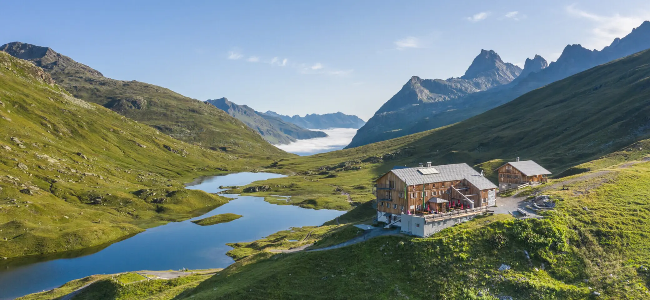 Blick auf die Neue Heilbronner Hütte vor einer Bergpanorama | © DAV Heilbronn