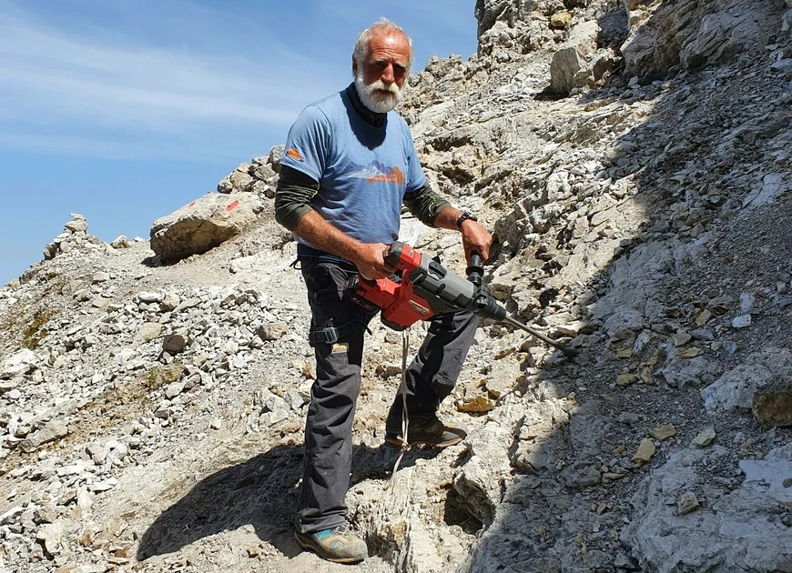DAV Heilbronn Team | © DAVHn ein älterer, aber fitter und kräftiger Mann in den Bergen mit Werkzeug und Arbeitsklamotten, sowie kurzen weißen Haaren und einem Vollbart | © DAVHn
