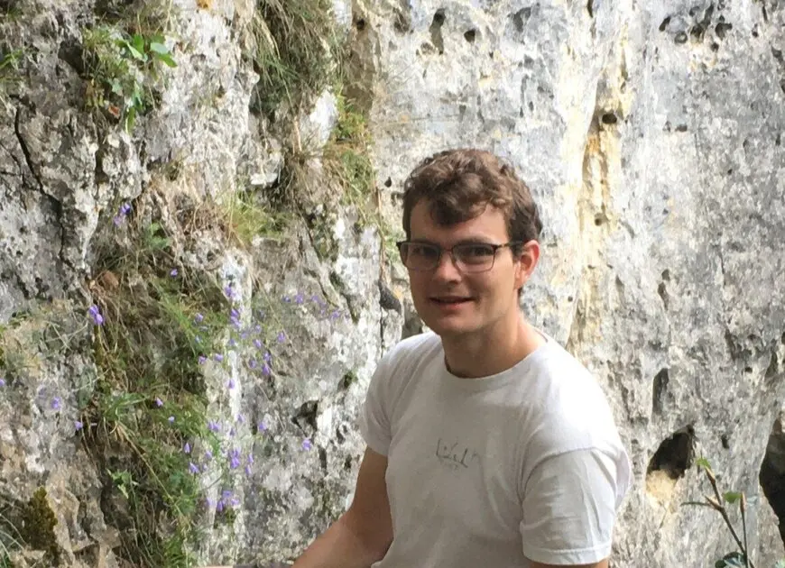 lächelnder junger Mann an einem Felsen mit Brille und kurzen blonden Haaren | © DAV Heilbronn