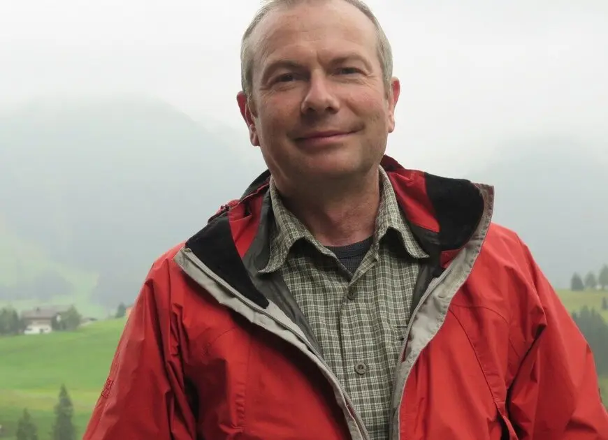 Mann mit kurzen, grauen Haaren und einer roten Regenjacke in den Bergen | © DAV Heilbronn